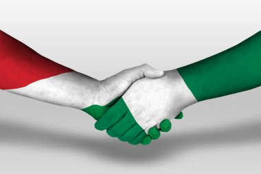 Handshake between nigeria and hungary flags painted on hands, illustration with clipping path.