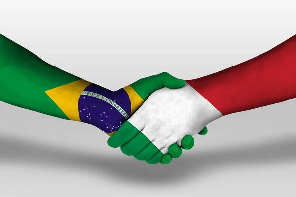 Handshake between italy and brazil flags painted on hands, illustration with clipping path.