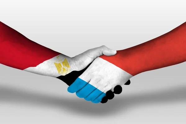 Рукопожатие Между Флажками Люксембурга Египта Раскрашенными Руках Иллюстрация Вырезкой — стоковое фото