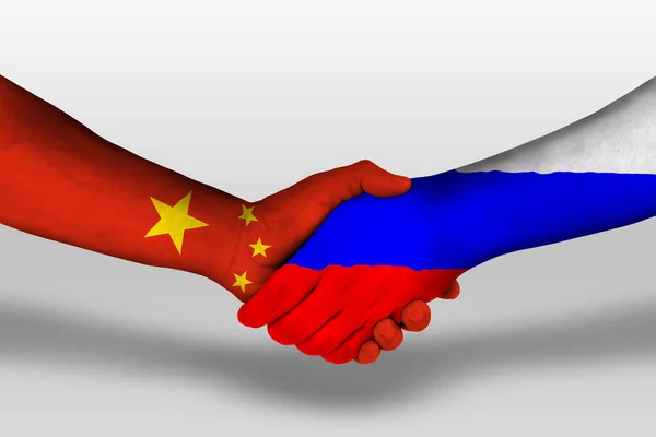 Рукопожатие Между Российскими Китайскими Флагами Раскрашенными Руках Иллюстрация Вырезкой — стоковое фото