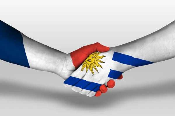 Рукопожатие Между Уругвайскими Французскими Флагами Раскрашенными Руках Иллюстрация Вырезкой — стоковое фото