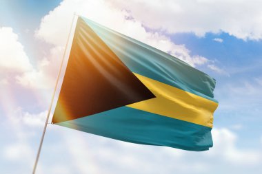 Güneşli mavi gökyüzü ve Bahamalar bayrağıyla bayrak direği