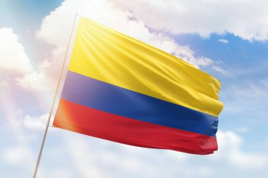 Sunny blue sky and a flagpole with the flag of colombia