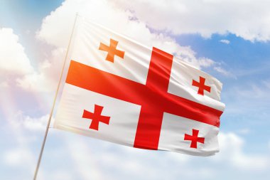 Güneşli mavi gökyüzü ve Gürcistan bayrağıyla bayrak direği