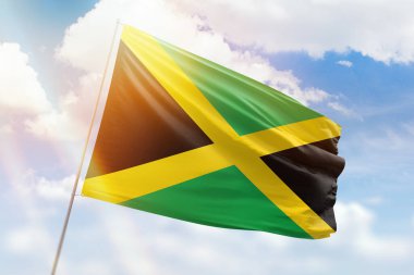 Güneşli mavi gökyüzü ve Jamaika bayrağıyla bayrak direği
