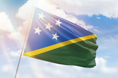 Güneşli mavi gökyüzü ve Süleyman adalarının bayrağıyla bayrak direği