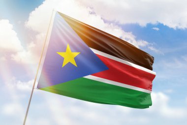 Güneşli mavi gökyüzü ve Güney Sudan bayrağıyla bayrak direği