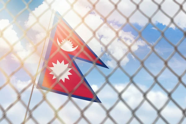 A steel mesh against the background of a blue sky and a flagpole with the flag of nepal