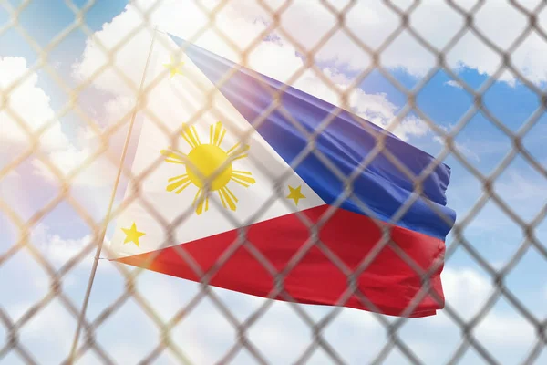 A steel mesh against the background of a blue sky and a flagpole with the flag of philippines