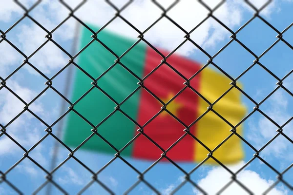 A steel mesh against the background of a blue sky and a flagpole with the flag of cameroon