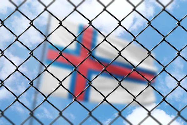 A steel mesh against the background of a blue sky and a flagpole with the flag of faroe islands