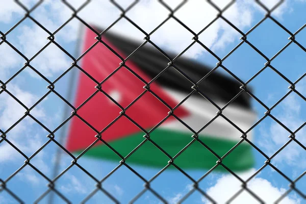 A steel mesh against the background of a blue sky and a flagpole with the flag of jordan