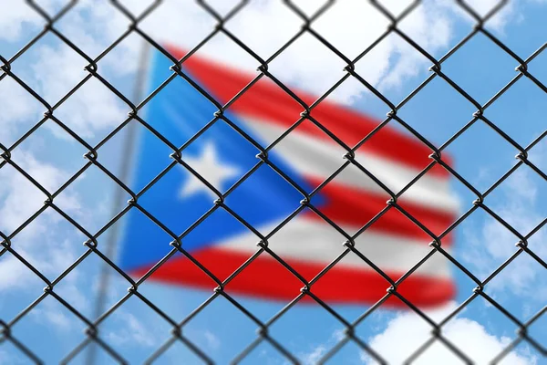 A steel mesh against the background of a blue sky and a flagpole with the flag of puerto rico