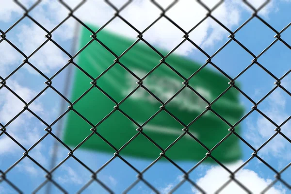 A steel mesh against the background of a blue sky and a flagpole with the flag of saudi arabia