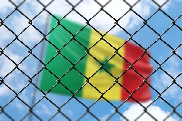 A steel mesh against the background of a blue sky and a flagpole with the flag of senegal