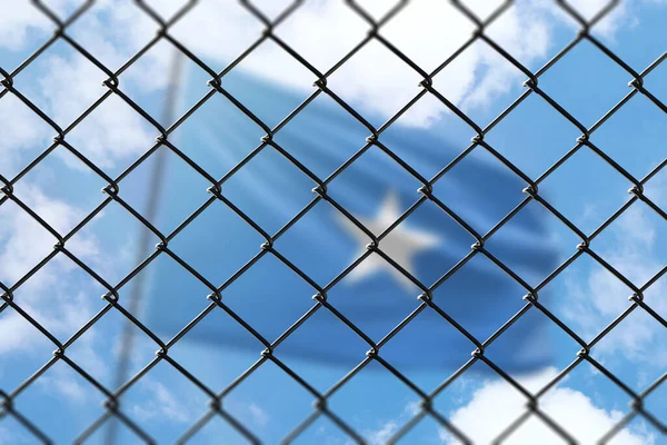 A steel mesh against the background of a blue sky and a flagpole with the flag of somalia