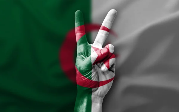 Hand making the V victory sign with flag of algeria
