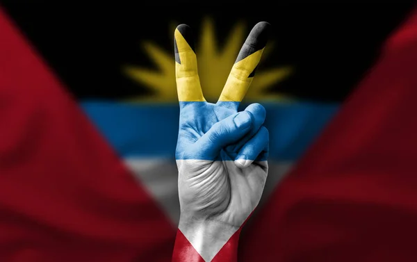 Hand making the V victory sign with flag of antigua barbuda
