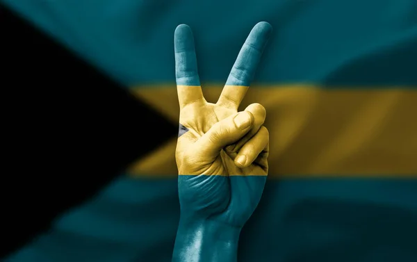 Hand making the V victory sign with flag of bahamas