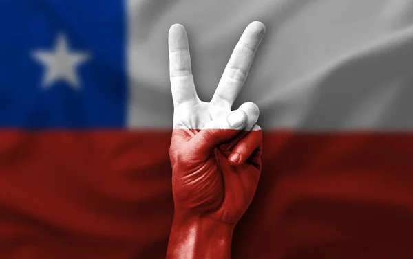 Hand making the V victory sign with flag of chile