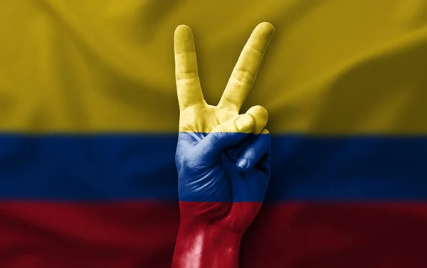 Hand making the V victory sign with flag of colombia
