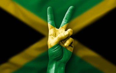 Hand making the V victory sign with flag of jamaica