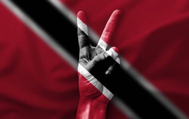 Trinidad Tobago bayrağıyla zafer işareti yapıyor.
