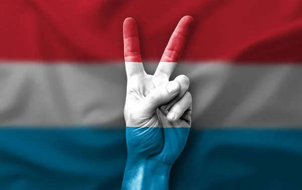 Hand making the V victory sign with flag of luxembourg