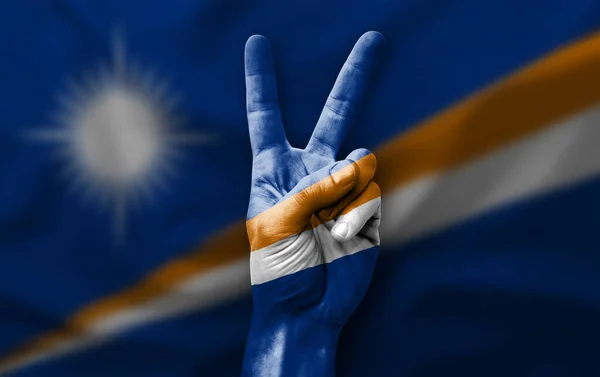 Hand making the V victory sign with flag of marshall islands