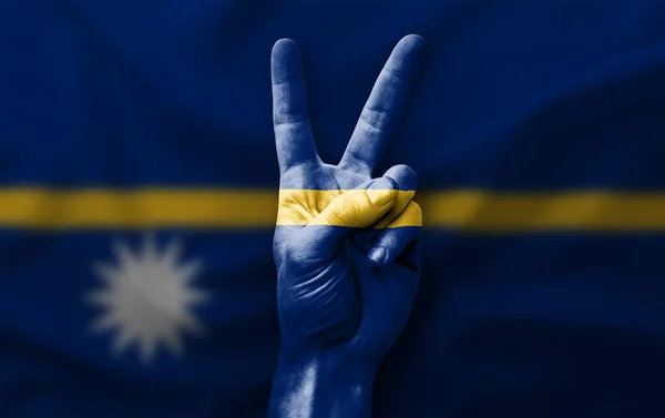 Hand making the V victory sign with flag of nauru