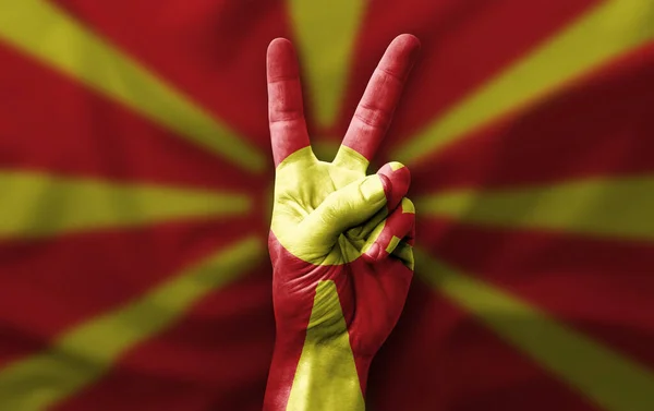 Hand making the V victory sign with flag of north macedonia