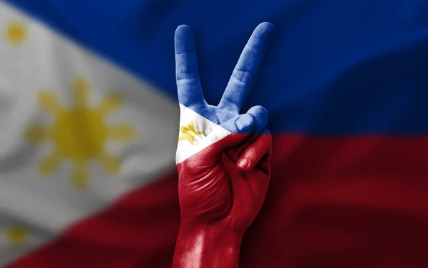 Hand making the V victory sign with flag of philippines