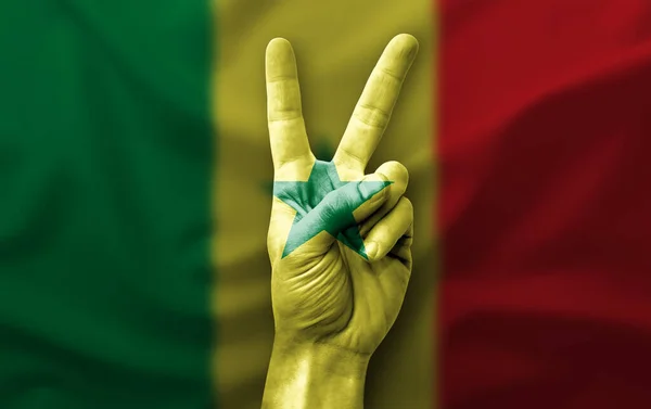 Hand making the V victory sign with flag of senegal