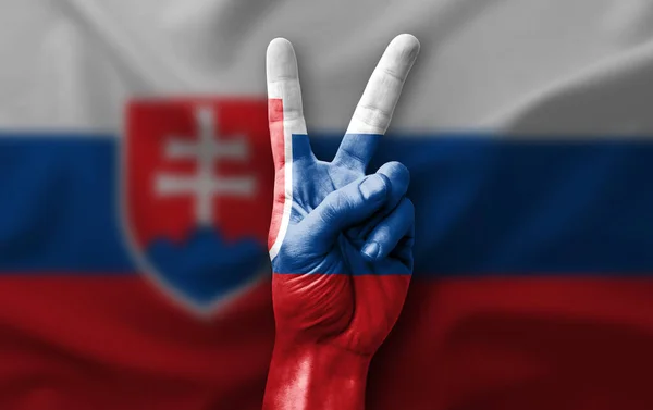 Hand making the V victory sign with flag of slovakia