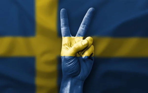 Hand making the V victory sign with flag of sweden