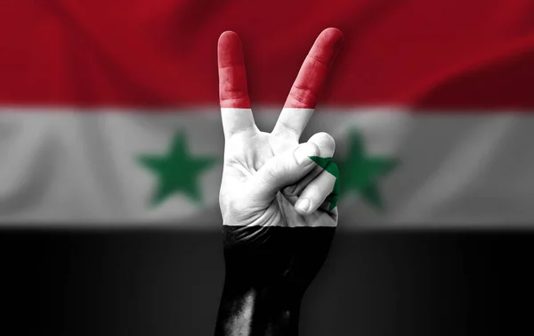 Hand making the V victory sign with flag of syria