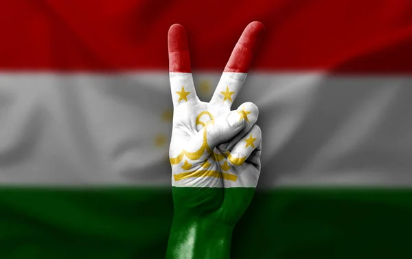 Hand making the V victory sign with flag of tajikistan