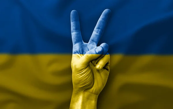 Hand making the V victory sign with flag of ukraine