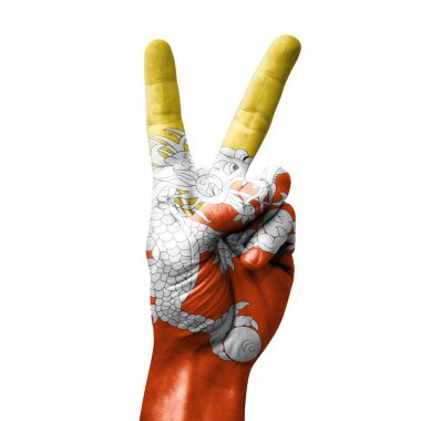 Bhutan bayrağıyla zafer işareti yapıyor.