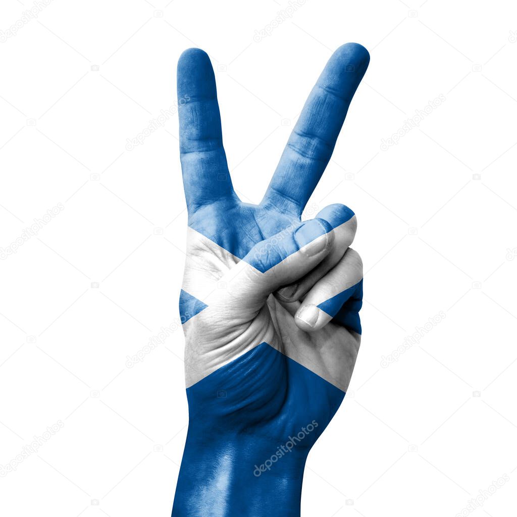 Hand making the V victory sign with flag of scotland