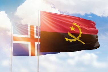 Sunny blue sky and flags of angola and iceland