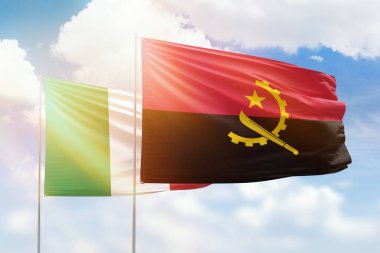 Sunny blue sky and flags of angola and italy