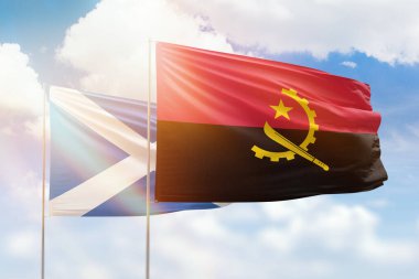 Sunny blue sky and flags of angola and scotland