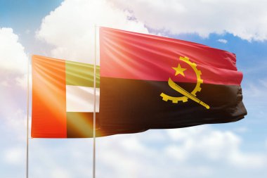 Sunny blue sky and flags of angola and uae