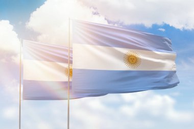 Sunny blue sky and flags of argentina and argentina