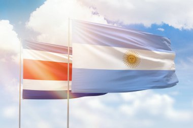 Sunny blue sky and flags of argentina and costa rica