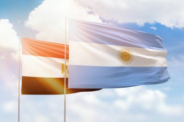 Sunny blue sky and flags of argentina and egypt