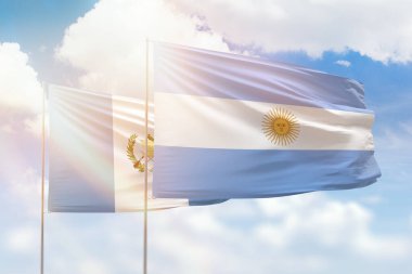 Sunny blue sky and flags of argentina and guatemala