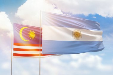 Sunny blue sky and flags of argentina and malaysia