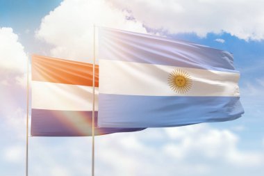 Sunny blue sky and flags of argentina and netherlands